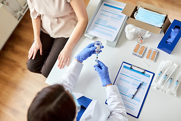 Image showing female doctor with syringe vaccinating patient