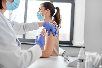 Image showing female doctor with syringe vaccinating patient