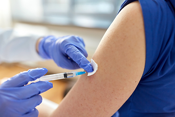 Image showing doctor with syringe vaccinating medical worker