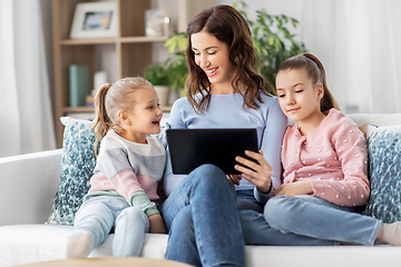 Image showing happy mother and daughters with tablet pc at home