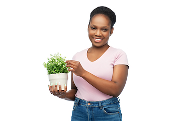 Image showing happy smiling african woman holding flower in pot