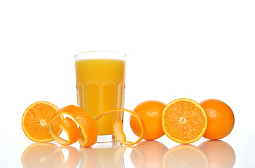 Image showing Glass of juice, oranges and orange peel