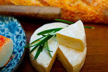 Image showing French cheese and fresh  baguette on a wood cutter