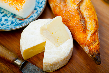 Image showing French cheese and fresh  baguette on a wood cutter