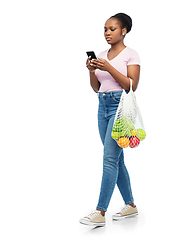 Image showing woman with smartphone and food in string bag