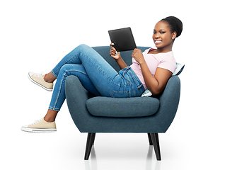 Image showing smiling woman with tablet pc sitting in armchair