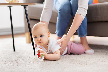 Image showing mother and baby playing with rattle at home