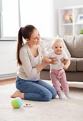 Image showing happy mother playing with little baby at home