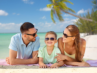 Image showing happy family lying over tropical beach background