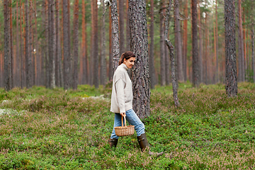 Image showing woman with basket picking mushrooms in forest