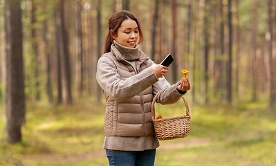 Image showing asian woman using smartphone to identify mushroom