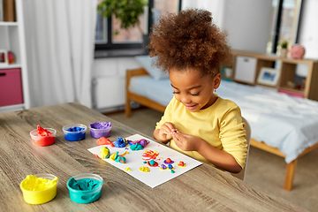 Image showing little girl with modeling clay playing at home