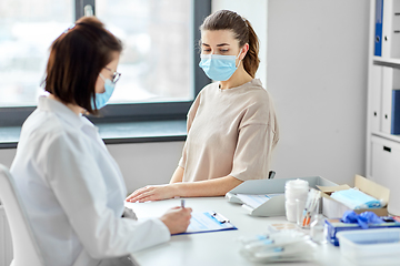 Image showing doctor with clipboard and patient at hospital