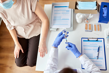 Image showing female doctor with syringe vaccinating patient