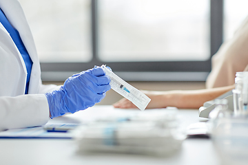 Image showing female doctor with syringe and patient at hospital