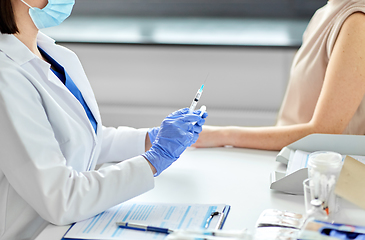 Image showing female doctor with syringe vaccinating patient