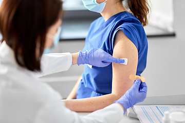 Image showing doctor attaching patch to medical worker