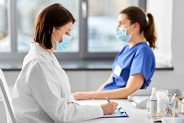 Image showing doctor with clipboard and nurse at hospital