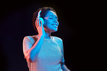 Image showing woman in headphones listening to music and dancing