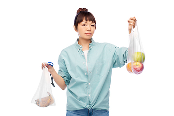 Image showing woman with fruits in reusable and plastic bags