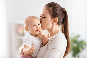 Image showing happy mother kissing little baby daughter at home