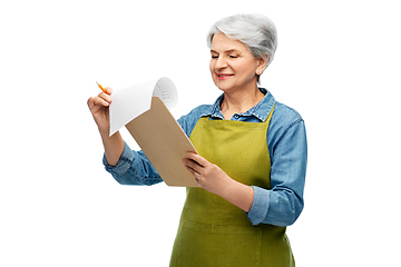 Image showing smiling old woman in garden apron with clipboard