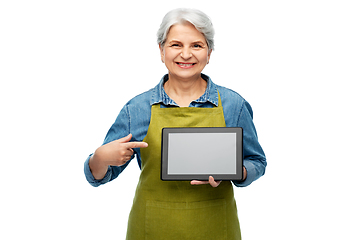 Image showing happy senior woman in garden apron with tablet pc