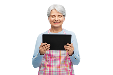 Image showing smiling senior woman in apron with tablet computer