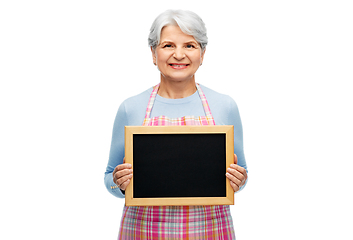 Image showing smiling senior woman in apron with chalkboard