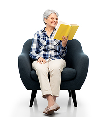 Image showing senior woman reading book sitting in armchair