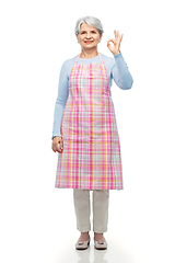 Image showing smiling senior woman in apron showing ok gesture