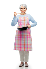 Image showing smiling senior woman in apron with frying pan