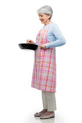 Image showing smiling senior woman in apron with frying pan