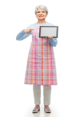 Image showing smiling senior woman in apron with tablet computer