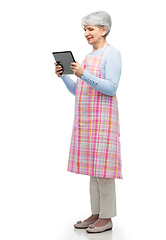 Image showing smiling senior woman in apron with tablet computer