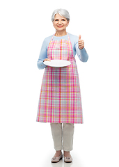 Image showing old woman in apron with plate showing thumbs up