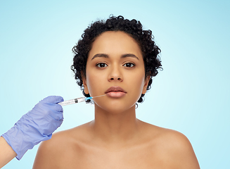 Image showing face of african woman and hand with syringe