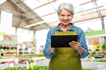 Image showing happy senior woman with tablet pc at garden store