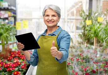 Image showing happy senior woman with tablet pc at garden store