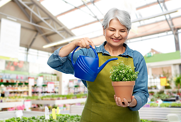 Image showing senior gardener with flower and watering can