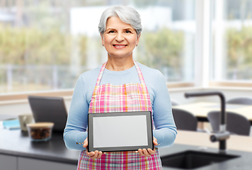 Image showing happy senior woman in apron with tablet pc at home