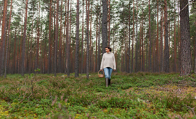 Image showing woman with basket picking mushrooms in forest