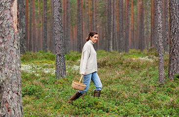 Image showing woman with basket picking mushrooms in forest