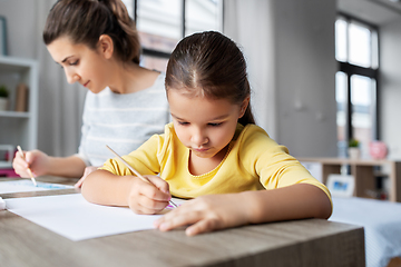 Image showing mother with little daughter drawing at home