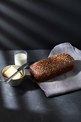 Image showing close up of bread, butter, knife and glass of milk