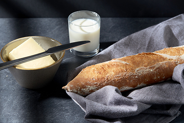 Image showing close up of bread, butter, knife and glass of milk