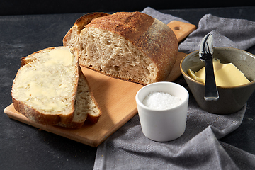 Image showing close up of bread, butter, knife and salt on towel