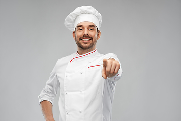 Image showing happy smiling male chef in toque pointing to you