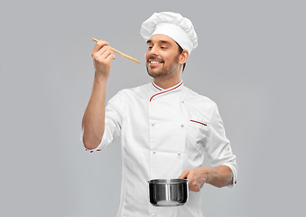 Image showing happy smiling male chef with saucepan tasting food