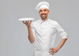 Image showing happy smiling male chef holding empty plate